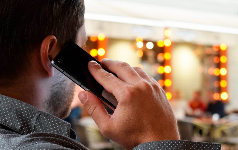 Hombre llamando por teléfono a Artisnova para la decoración de su local